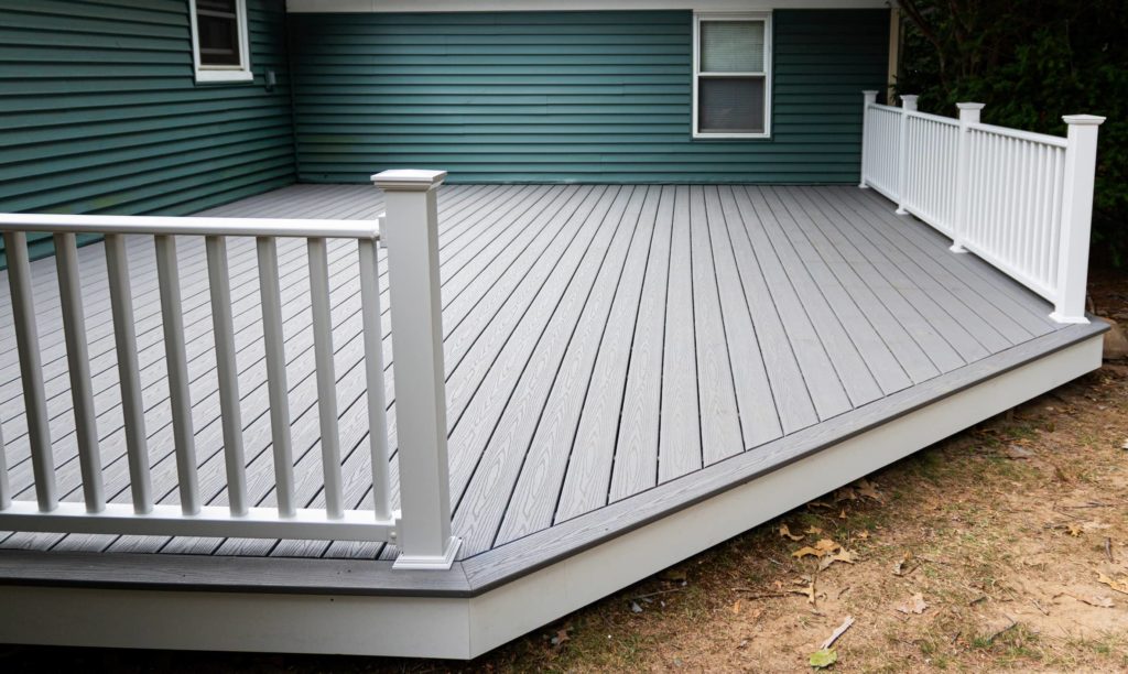 This image shows a white and gray wooden deck for a home's backyard.
