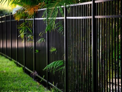 This image is of a tall metal fence surrounding a property.